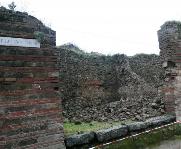 Pompeii. December 2004. Via degli Augustali looking west at side wall of VII.2.1 