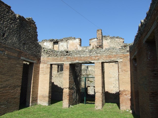 VII.2.18 Pompeii. March 2009. Room 9, north wall of cubiculum or porter’s room with window to Vicolo del Panettiere. The upper north wall would have been the upper floor and belonged to a separate apartment. The recess that can be seen would have been the latrine.
