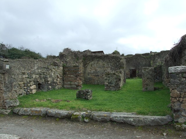 VII.3.4 Pompeii. March 2009. East side of shop, looking south east across site of  counter, with remains of 3 urns.