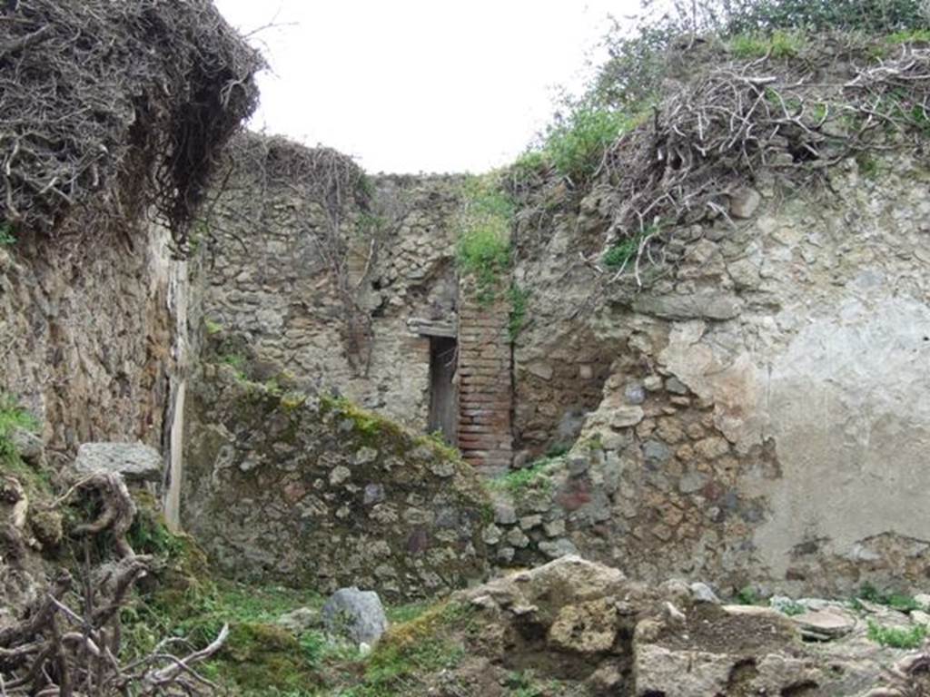 VII.3.21 Pompeii. March 2009. Looking west towards garden area of VII.3.21. This is at the rear of the triclinium of VII.3.13, in the foreground. Apart from the garden area, there was also a small room or cupboard, kitchen and latrine. According to Boyce, in the east wall of the kitchen between the hearth and the latrine, was a small rectangular niche. Inside the niche, its walls were coated with red stucco.
See Boyce G. K., 1937. Corpus of the Lararia of Pompeii. Rome: MAAR 14. (p. 64, no. 268)