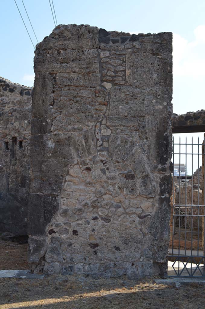 VII.4.31/51 Pompeii. September 2019.
Pilaster on east side of atrium, with filled in niche, between doorways to room 9, and entrance doorway into room 10, leading to VII.4.33, on right.
Foto Annette Haug, ERC Grant 681269 DÉCOR.
(Note: our numbers are different to other plans,
- PPM would indicate a pilaster between rooms 10 and 11,
- Descoeudres used the same numbering).
According to Descoeudres – in the atrium “above this high marble veneered dado, the walls were painted.
None of the paintings are extant, but the 19th century excavation notes mention one of them which at the time was still to be seen.
It is described as “a bizarre frieze showing the carriage of Bacchus (or Dionysus) with 2 panthers yoked to it, and on either side garlands of grapes against which 2 ladders rest with 2 cupids climbing up”.
(In the archive of NAP there is a water colour tracing which obviously depicts half of this frieze. (Fig 40, page 69). One can see that the carriage contained a mask of Dionysus and not Dionysus himself. Since it is a tracing it is at actual size and it is clear that the full frieze, which must have been the border of a large panel must have been at least 1.5m wide. There are not many long stretches of wall in the atrium which was surrounded by many entrances and doors, and the only wall in the atrium at the time of excavation that was long enough to accommodate such a large panel was that between rooms 10 and 11.
Closer examination of this wall also reveals a niche, which at some stage was badly damaged (by earthquake?).
The vertical crack which can still be seen is typical of earthquake damage). The wall was later repaired and the niche filled in.
This was probably the site of the original Lararium – this is usually located in the atrium, but in this house it is located in the west ala (7). (Note: our room 6).
It was probably moved there after the earthquake, probably after 62AD.
The wall where it had originally stood was then repaired and covered with marble veneer.
If this interpretation is correct, then the application of marble veneer to the atrium walls must have been done after 62 AD.”
See Descoeudres J-P., Ed., 1994. Pompeii Revisited: The life and death of a Roman town. Sydney: Meditarch, (p.70-71).