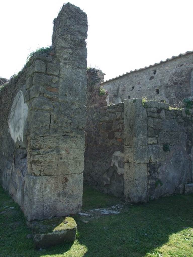 VII.4.57 Pompeii. March 2009. Pillar between the tablinum (left) and doorway to room 8, corridor to rear (right).
The large block of lava stone in front of the pillar is the remains of the base for the arca/strong-box, which was originally surrounded by a small rectangular wall.
(PPM and Avellino – room q, corridor, area f, strong-box or arca.)