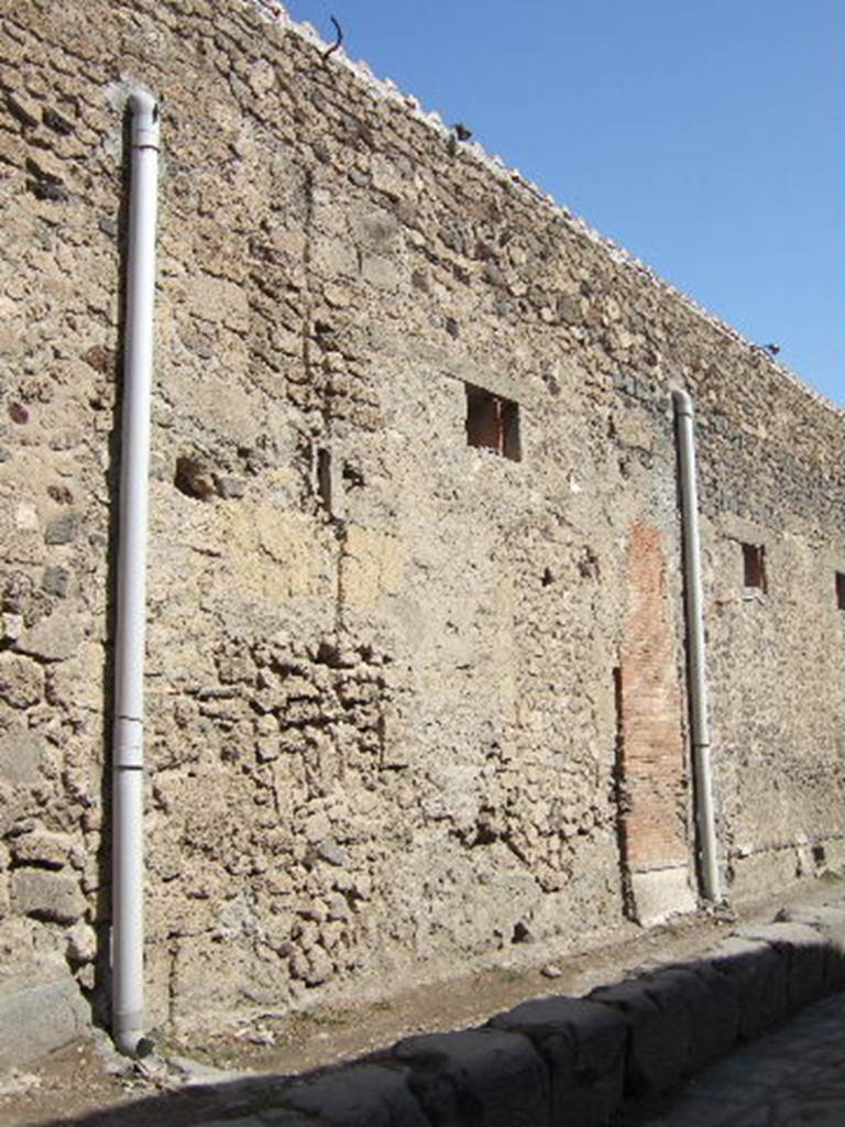 VII.5.17 Pompeii. September 2005. Looking north-east towards site of entrance doorway. According to Garcia y Garcia, all of the south-west corner and southern part of the insula were transformed in the time of Maiuri. Then the area was hit during the first bombing incursion during the early evening (17.00hrs) of 13th September 1943. All of the old structures that remained have been modified again to provide a restaurant, toilets and sales area. The modifications included closing and bricking up of the old doorways to VII.5.14, 15, 16 and 17. Entrances at VII.5.18, 19 and 20 now provide the doorways to the modern restaurant. 
See Garcia y Garcia, L., 2006. Danni di guerra a Pompei. Rome: L�Erma di Bretschneider. (p.101-3).
