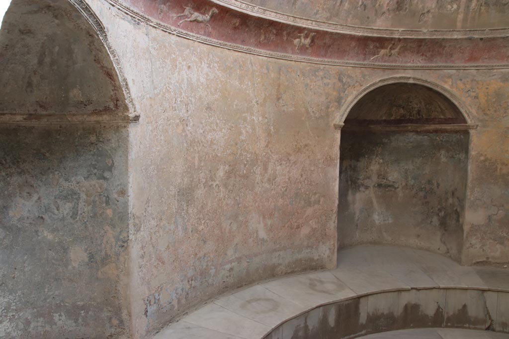 VII.5.24 Pompeii. October 2023.
Frigidarium (19) with two of the four niches (20) with stucco cornice above. Photo courtesy of Klaus Heese.