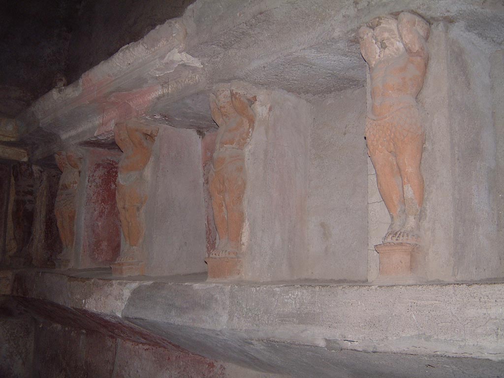 VII.5.24 Pompeii. May 2001. Tepidarium (37), looking west along north wall, detail of telamons separating the niches.
Photograph courtesy of Current Archaeology.