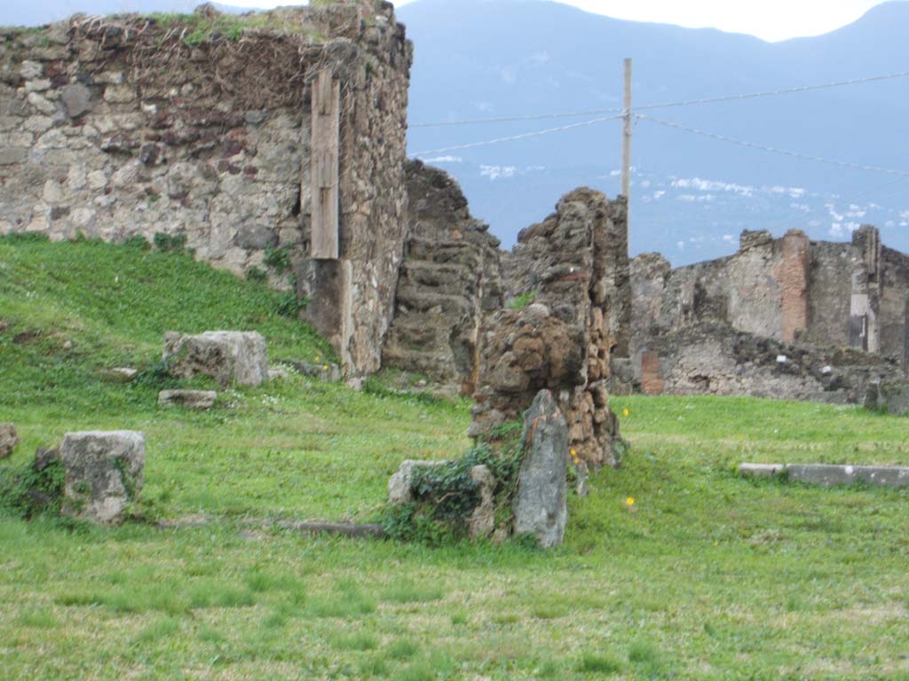 VII.6.7 Pompeii. December 2004. Looking south across remains of tablinum and the oecus on its east side, in forefront of photo.
At the rear can be seen the stairs (centre) and the site of the peristyle, through the tablinum.
The column against the wall on the left, would appear to be in the doorway of Room 51.
On the immediate left would be the area of room 49, a triclinium.
According to Blake, commenting on the damage done by the winter weather, stated that –
“The vase/kantharos which once formed the threshold of a triclinium opening off the peristyle of VII.6.7 disappeared almost completely during the winter of 1928”.
See Blake, M., (1930). The pavements of the Roman Buildings of the Republic and Early Empire. Rome, MAAR, 8, (p.12).