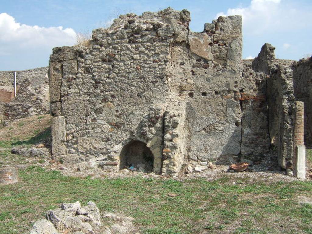 VII.6.7 Pompeii. September 2005. Stairs of the east wall of the peristyle of VII.6.7 are on the left, The east wall of the latrine of VII.6.7 is centre left, and VII.6.28 on the right, behind the column. According to Spano in NdS, at the rear of the eastern walkway (of the peristyle) there was a brick staircase with an arch below. This staircase led up to some rooms existing above the ground floor rooms numbered 56 and 57. The entry to these two rooms was through a small doorway on the right of the staircase. Of these two rooms, number 56 was the latrine, and number 57 was the kitchen. See Spano in Notizie di Scavi, 1910, (p.460)