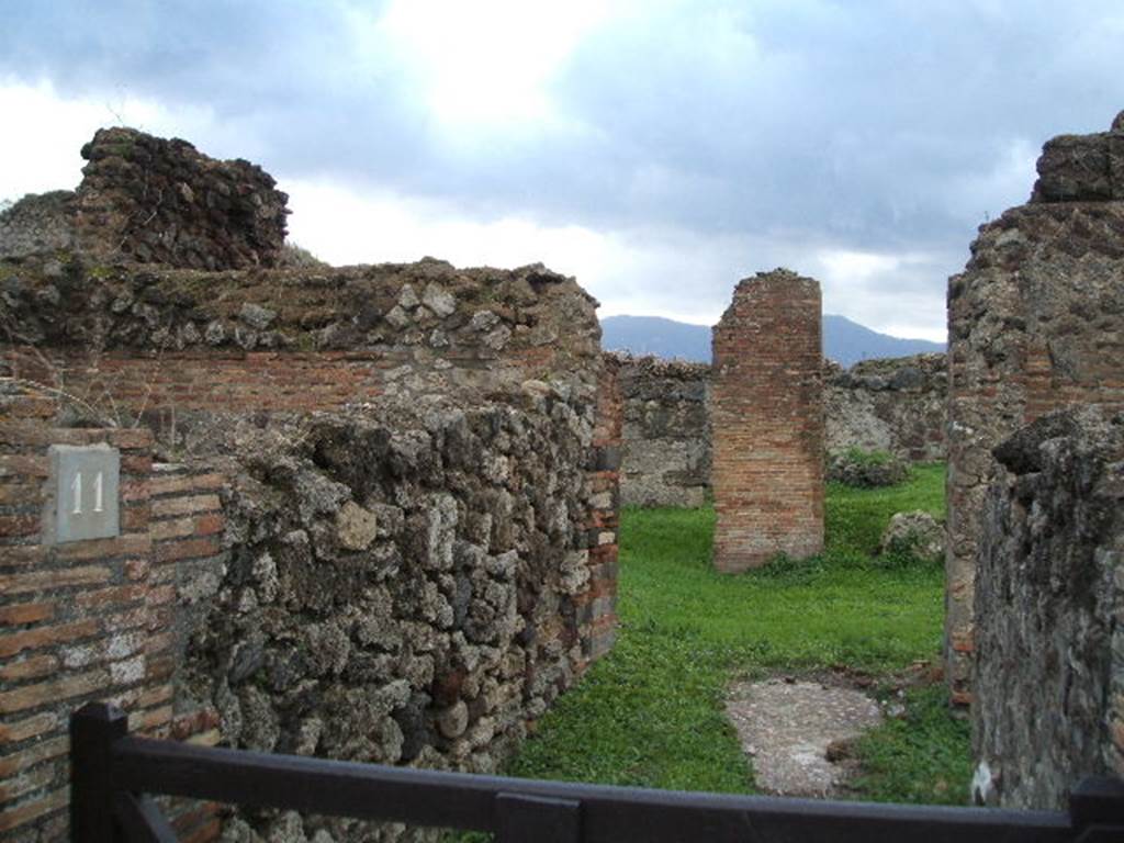 VII.6.11 Pompeii. December 2004. Looking south along entrance corridor towards site of atrium. This area was affected by the bombing in September 1943. A photograph of the area can be seen showing the same brick pilaster, about the only thing left standing in the area. See Garcia y Garcia, L., 2006. Danni di guerra a Pompei. Rome: L’Erma di Bretschneider. (p.104, Fig 233 (Foto SAP neg. no.176)