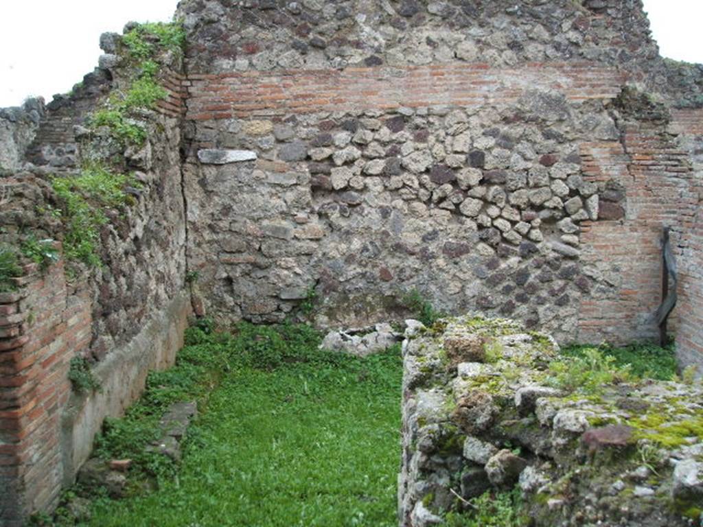 VII.6.15 Pompeii. December 2004. Looking west across south side of bar-room. In the south wall, in the left-front of the photo, is a doorway leading through to the long room.  In the south-west corner at the rear can be seen the remains of a structure. Fiorelli called it  �un sedile di Fabbrica� (a seat of masonry).  Eschebach called it a �zweischenkeliger Herd� (a two-legged hearth).
See Pappalardo, U., 2001. La Descrizione di Pompei per Giuseppe Fiorelli (1875). Napoli: Massa Editore.(p.160)
See Eschebach, L., 1993. Geb�udeverzeichnis und Stadtplan der antiken Stadt Pompeji. K�ln: B�hlau. (p.294)
