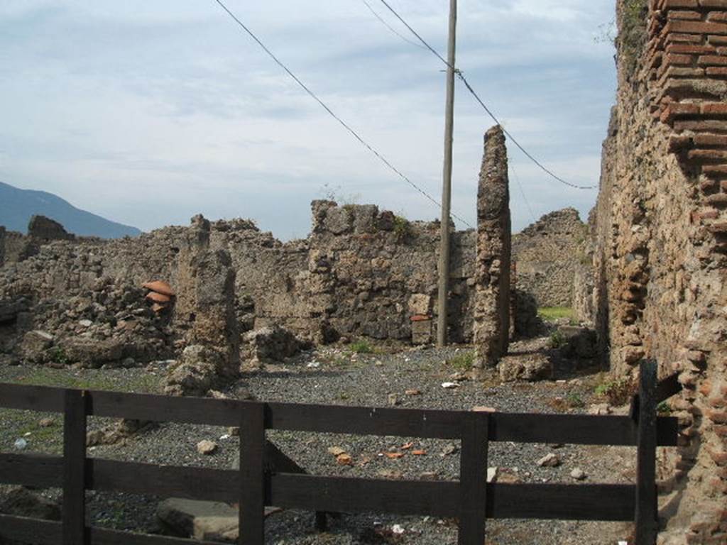 VII.6.19 Pompeii. May 2005. Looking west. According to Eschebach, on the north side (right) was a stairs to the upper floor. On the south side, (left) was a sales-table, together with doorway to VII.6.20. On the west side, the rear room had a doorway to VII.6.28 with 4 dormitories behind VII.6.17 &18, for the workers?
See Eschebach, L., 1993. Gebäudeverzeichnis und Stadtplan der antiken Stadt Pompeji. Köln: Böhlau. (p.296)
