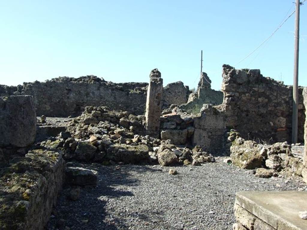 VII.6.20 Pompeii. March 2009. Looking west towards site of rear room, and small yard or garden. 
This site would be approximately under the pile of stones.
According to Eschebach, on the north side (right) would have been separate steps to the upper floor dwelling above the doorway to VII.6.19.
On the west side would have been a rear room, a second stairs to the upper floor, a latrine and a small yard and garden.
See Eschebach, L., 1993. Geb�udeverzeichnis und Stadtplan der antiken Stadt Pompeji. K�ln: B�hlau. (p.296)


