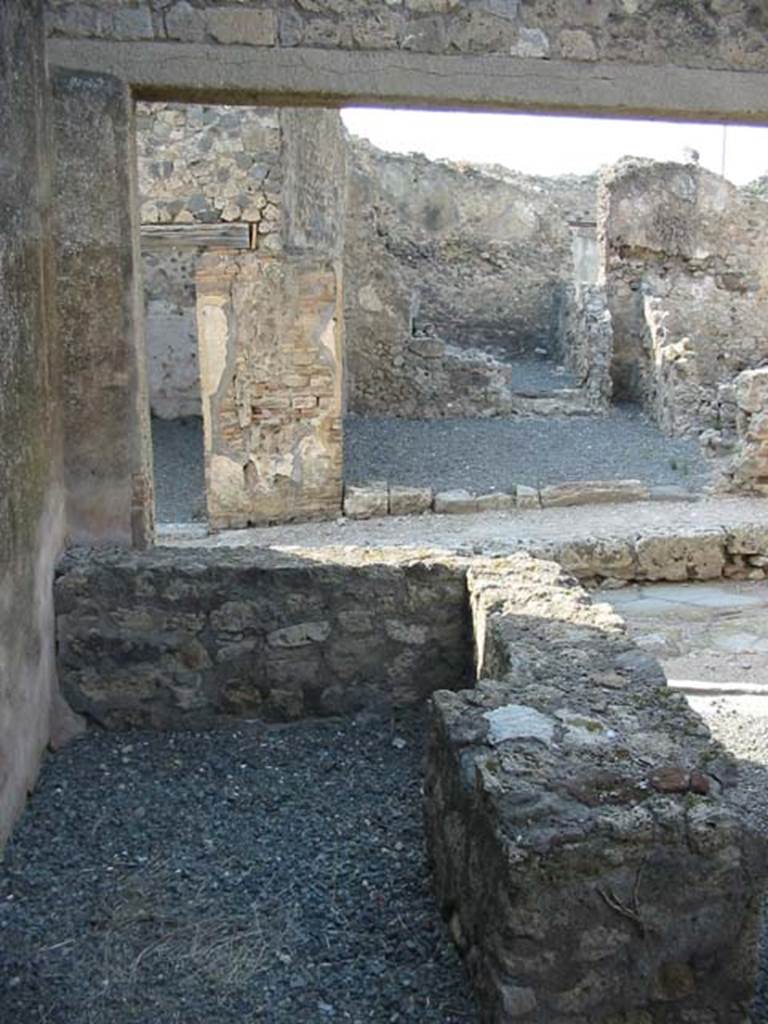 VII.7.18 Pompeii. May 2003.
Looking north across rear of counter with hearth, towards VII.6.33, opposite on Vicolo dei Soprastanti.
Photo courtesy of Nicolas Monteix.