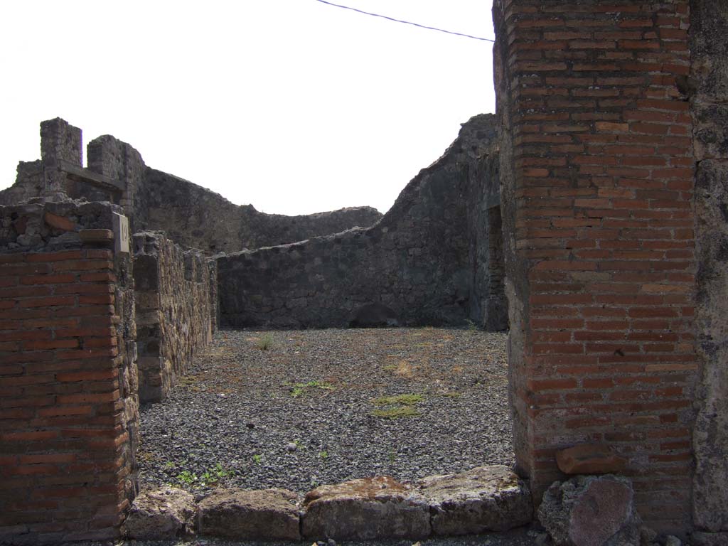 VII.7.19 Pompeii. September 2005. Looking south from entrance directly into atrium.
According to Eschebach, in the middle of the south wall would have been a lararium.
On the left can be seen doorways to an oecus with stairs to upper floor, and a triclinium fenestratum.
See Eschebach, L., 1993. Gebäudeverzeichnis und Stadtplan der antiken Stadt Pompeji. Köln: Böhlau. (p.302)
According to Boyce –
in the centre of the south wall of the large central room was a rectangular niche; in the west wall, near the floor, was an arched niche.
The latter was called the lararium by Fiorelli, although the former was more like the usual shrine.
See Boyce G. K., 1937. Corpus of the Lararia of Pompeii. Rome: MAAR 14. (p.68, no.300)