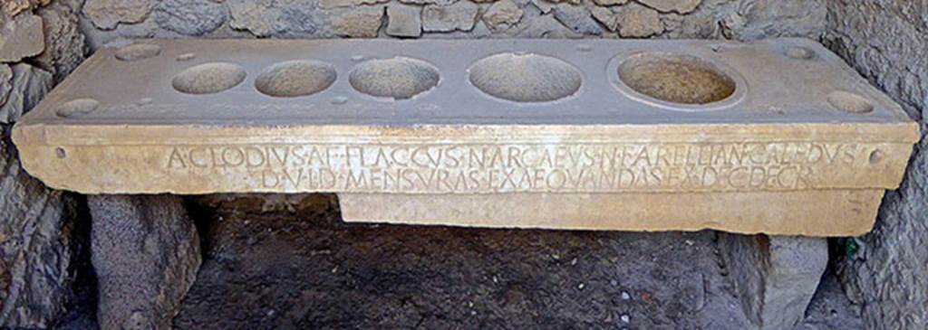 VII.7.31 Pompeii. September 2016. Mensa Ponderaria, with inscription on the front.
Photo courtesy of Michael Binns.
Original now kept in Naples Archaeological Museum. Inventory number 3828.

According to Epigraphik-Datenbank Clauss/Slaby (See www.manfredclauss.de), it read �

A(ulus) Clodius A(uli) f(ilius) Flaccus N(umerius) Arcaeus N(umeri) f(ilius) Arellian(us) Caledus
d(uum)v(iri) i(ure) d(icundo) mensuras exaequandas ex dec(urionum) decr(eto)      [CIL X 793]

According to Cooley this translates as:
Aulus Clodius Flaccus, son of Aulus, and Numerius Arcaeus Arellianus Caledus, son of Numerius, duumvirs with judicial power, saw to the standardization of the measures in accordance with a decree of the town councillors.
See Cooley, A. and M.G.L., 2004. Pompeii: A Sourcebook. London: Routledge, H64b, p. 179.
