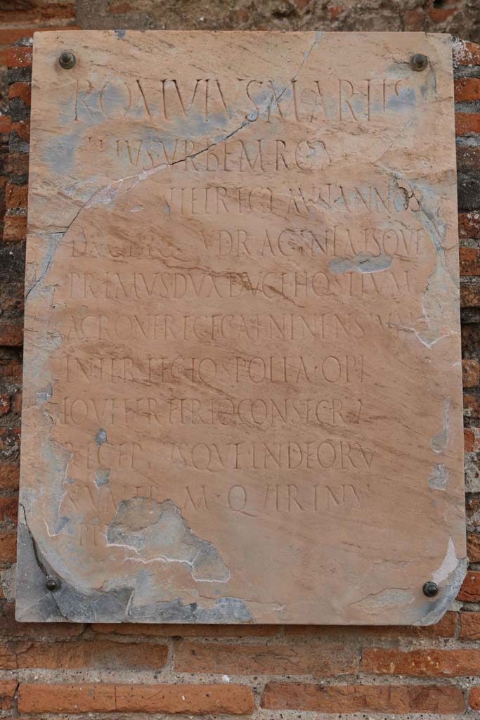 VII.9.1, Pompeii. December 2018. Portico 1. North end.
Plaque to Romulus, son of Mars, situated below niche between entrance and apsidal niche 4.
Photo courtesy of Aude Durand.