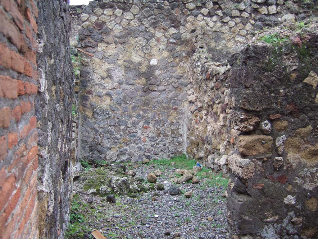 VII.9.33 Pompeii. December 2005.
Looking west, from site of steps to upper floor at VII.9.32. At rear is a room on the north side of the atrium of VII.9.33.