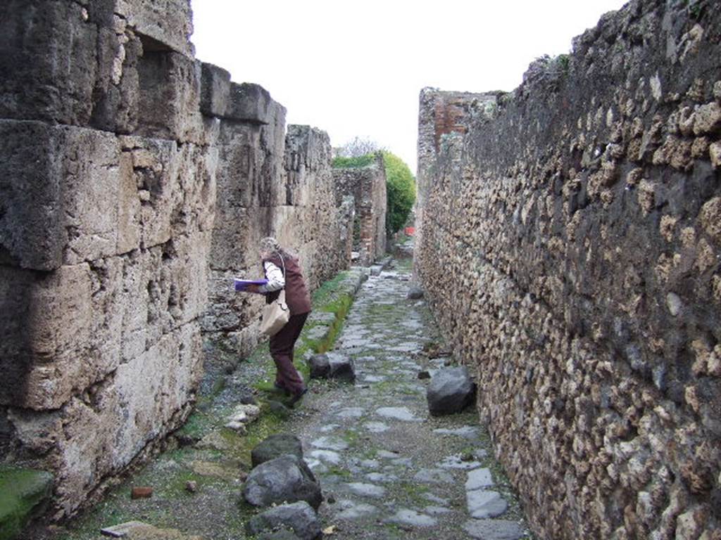 VII.9.64 and VII.9.63 Pompeii. December 2005. Vicolo degli Scheletri looking east. Eumachia�s building on right.
