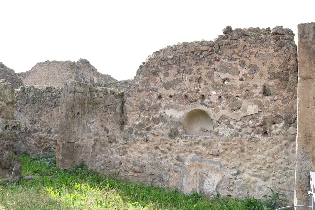 VII.12.12, Pompeii. December 2018.
Looking towards west wall with arched niche. On the left is the corridor leading to the rear yard, with kitchen and latrine.
Photo courtesy of Aude Durand.