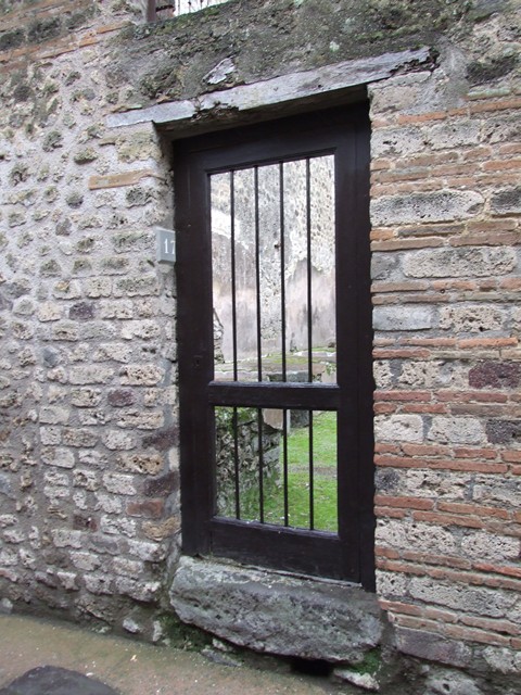 VII.12.17 Pompeii. December 2006. Looking from entrance doorway towards doorway into VII.12.21. A brick and tile hearth with wood store underneath is on the right of the doorway.

