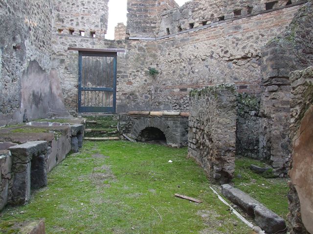 VII.12.17 Pompeii. March 2009. Looking east across south side, towards two round water basins set in podium, from VII.12.21. 
