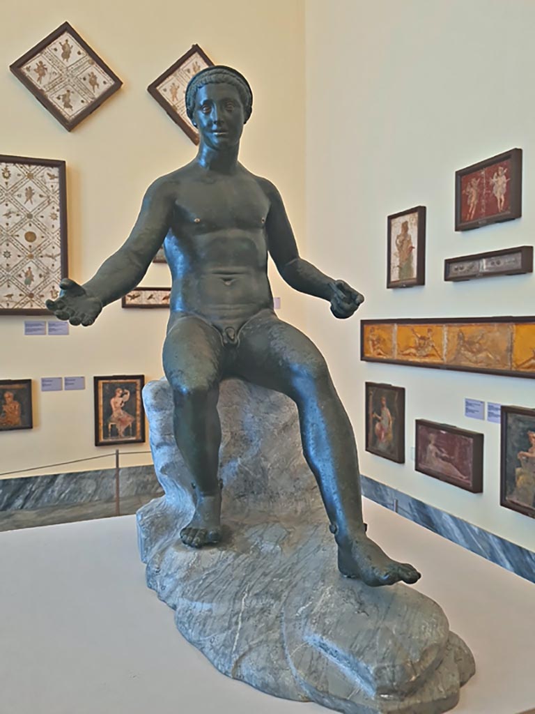 VII.12.23 Pompeii. October 2023. Bronze statue of Demetrios II. Photo courtesy of Giuseppe Ciaramella.
On display in “L’altra MANN” exhibition, October 2023, at Naples Archaeological Museum, inv. 4892.
According to Jashemski, this was found against the west wall and was a statuette of Mercury, seated on a rock (inv. 4892).