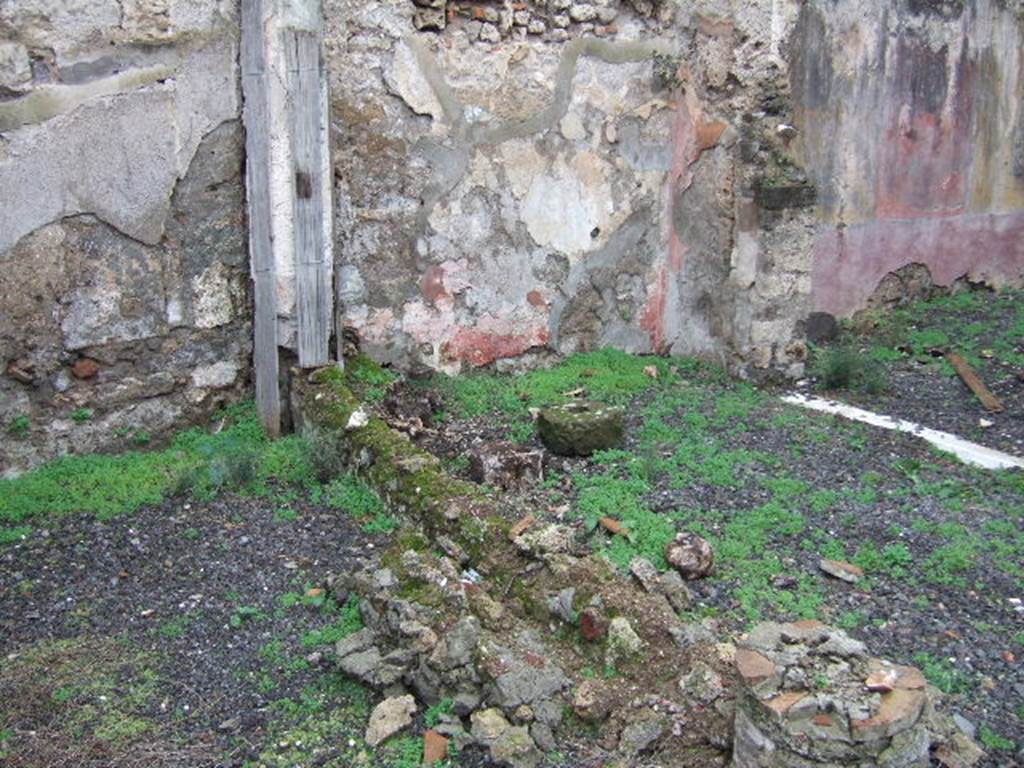 VII.12.26 Pompeii. West wall of garden area, North Portico and doorway to Triclinium. According to Boyce, there was a Lararium painting on the west end of the North Portico done on a white background. The Genius stood in the centre, with a Lar on either side. Below them, two serpents were approaching an altar. See Boyce G. K., 1937. Corpus of the Lararia of Pompeii. Rome: MAAR 14. (p.71, No.321).