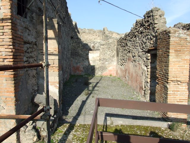VII.12.27 Pompeii. December 2005. Entrance with door to fauces of VII.12.26 on right and window in rear wall overlooking small garden of VII.12.26.