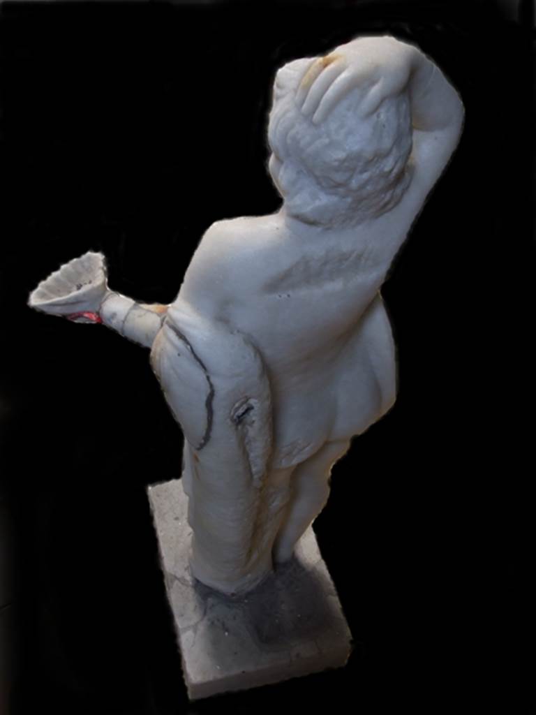 VII.12.28 Pompeii. Marble fountain statue of small boy with hand on head and holding a shell. Rear view showing pipework into arm. SAP inventory number 20395.