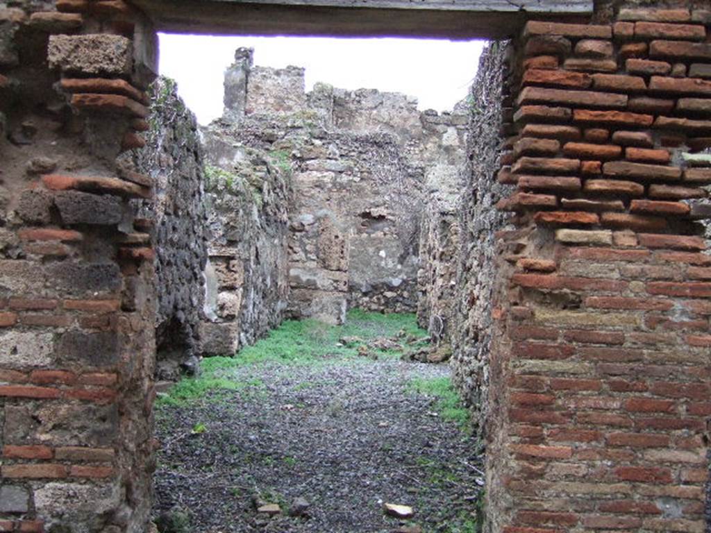 VII.12.31 Pompeii. Looking north through doorway to corridor. This used to contain steps to the upper floor, with a latrine underneath. Ahead at the rear was a cubiculum. On the left, a doorway leading to VII.12.32, on the right a doorway leading to VII.12.30.