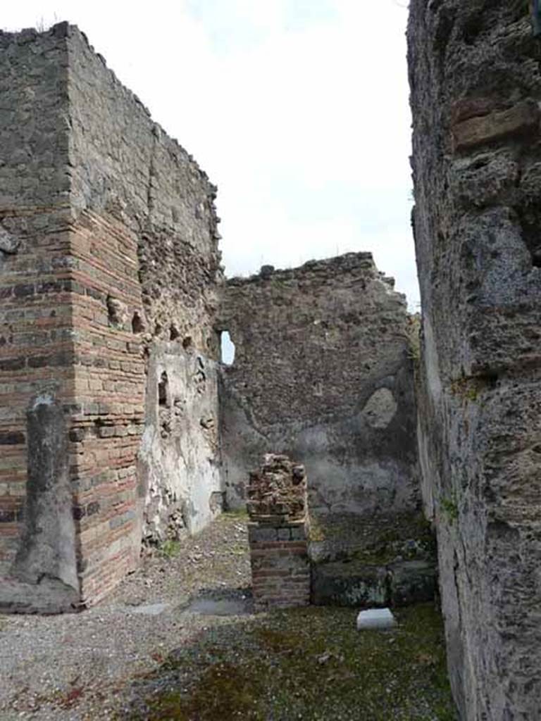 VII.13.4 Pompeii. May 2010. Looking east from entrance towards steps to upper floor and small storeroom.  According to Fiorelli �
A destra si trova la scaletta del piano superiore attigua ad un rustico cubicolo, che altro ne teneva accanto decorato nelle pareti con bustini rinchiusi in circolo, interamente svaniti,e da figurine isolate in mezzo a scompartimenti architettonici, che si riconoscono tuttavia per quelle di Venere pescatrice, di Paride (?) con Amore sull�omero e di Narciso in piedi con Amore allato che si specchia nell�onda. Indi evvi l�ala, che conteneva un grande armadio, e dalla quale entravasi nel cennato cubicolo, nonche in un compreso rustico probabilmente servito per deposito di quel generi, di cui il servo della casa faceva smercio nell�annessa bottega.
(trans.�To the right, one finds the stairs to the upper floor adjoining to a rustic cubiculum, while another nearby was decorated in the walls with heads enclosed in medallions, entirely faded and vanished, and by isolated figures in the midst of architectural decorations, which one could recognize however, as being Venus Pescatrice, of Paris (?) with Cupid on the shoulder and of Narcissus standing with Cupid who was reflected in the water. 
Then there was the ala, which contained a large cupboard, and from which one entered into the indicated cubiculum, the rustic room probably served for storage of those things which the servant of the house sold in the adjoining shop.�)
Fiorelli, G: Descrizione di Pompei, 1875. (p.295-6)
