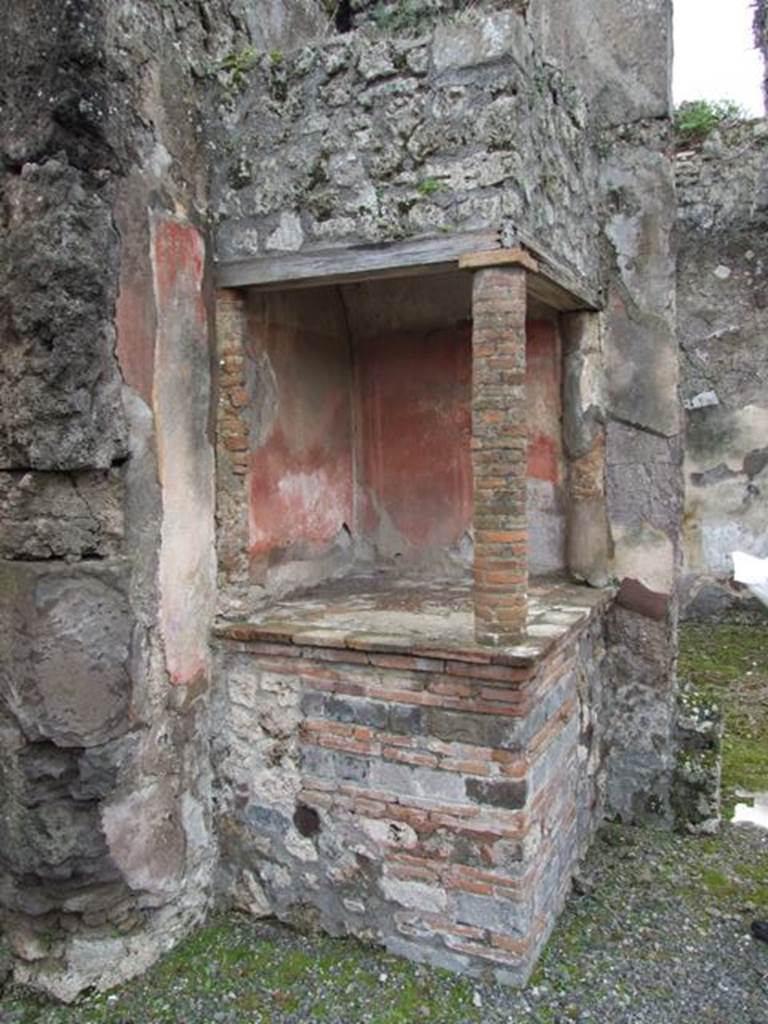 VII.14.5 Pompeii. March 2009. Aedicula lararium in south-west corner of atrium. According to Boyce, above a solid podium one column and two half columns applied to the south and west walls supported a roof. This formed a kind of niche, the ceiling of which was vaulted. The inside walls were painted red like those of the room.
See Boyce G. K., 1937. Corpus of the Lararia of Pompeii. Rome: MAAR 14. (p.71, no.326) 
