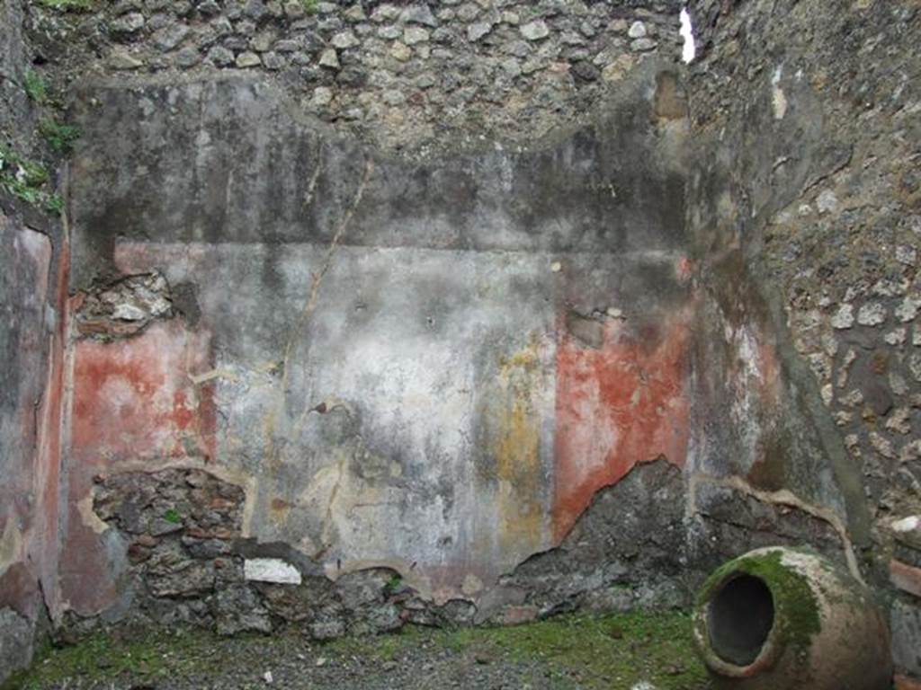 VII.14.5 Pompeii. March 2009. Room 13, south wall with remaining painted plaster. 
The wall would have been painted in the IV Style, with red panels framed by �carpet� borders and two parallel lines.
The borders would have been separated by architectural decoration which showed, according to Fiorelli, three paintings with fish and landscape. 
No trace of these paintings survives on the south wall.
