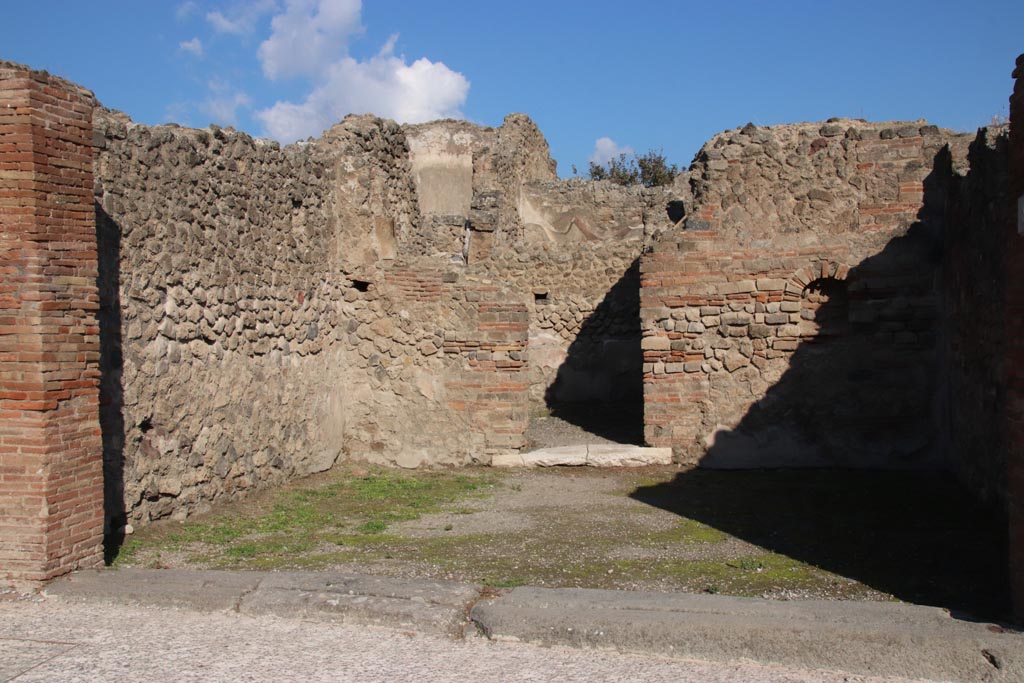 VII.14.8 Pompeii. May 2005. Looking towards north wall of shop, with niche and doorway to rear room.