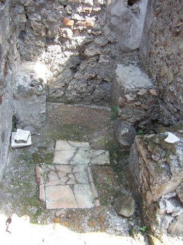 VII.15.3 Pompeii. September 2005. Looking north across atrium.
A cubiculum is on the left, in the middle there is a corridor to garden and triclinium. On the right is another cubiculum, and three stone steps leading to a stairs to upper floor, outlined on east wall.
