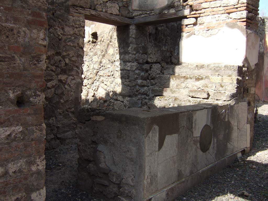 VII.15.5 Pompeii. December 2007. Detail of niche. Boyce recorded a female figure reclining on a kline or couch, under an awning. She was naked from the waist upwards and wearing a yellow robe from the waist down. In front was a three legged table on which were three jars. According to Fiorelli this figure was Libera.
See Boyce G. K., 1937. Corpus of the Lararia of Pompeii. Rome: MAAR 14.  (p. 72, no.330, plate 12,3).
See Fiorelli G., 1875. Descrizione di Pompei. Napoli. (p. 310).
