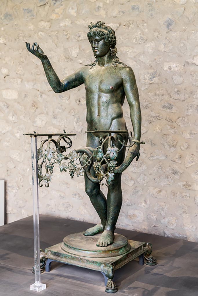 VII.16.17-22 Pompeii. January 2023.
Bronze Ephebe lamp-holder (lampadophoro) from oecus 62, on display in exhibition in Palaestra.
Photo courtesy of Johannes Eber.