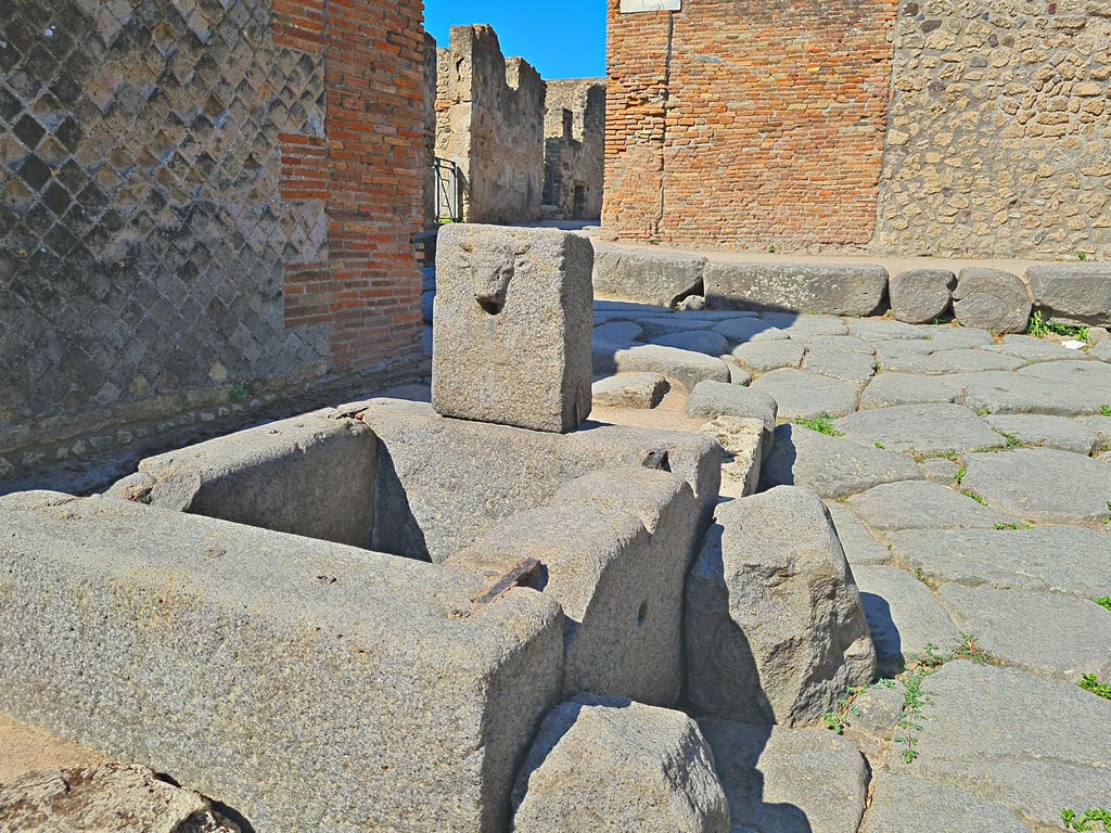 VIII.2.29, on left. April 2022. Looking west across fountain in Via della Regina. Photo courtesy of Giuseppe Ciaramella.