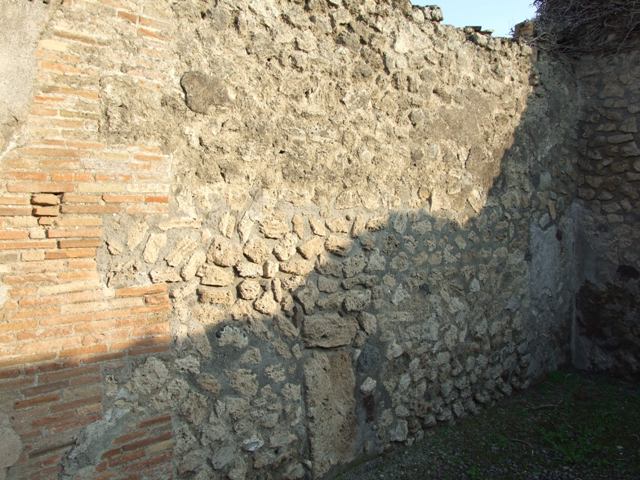 VIII.3.5 Pompeii. December 2005.  Remains of plaque with pieces of tessellated stone and mosaic on wall between VIII.3.6 and VIII.3.5.   

