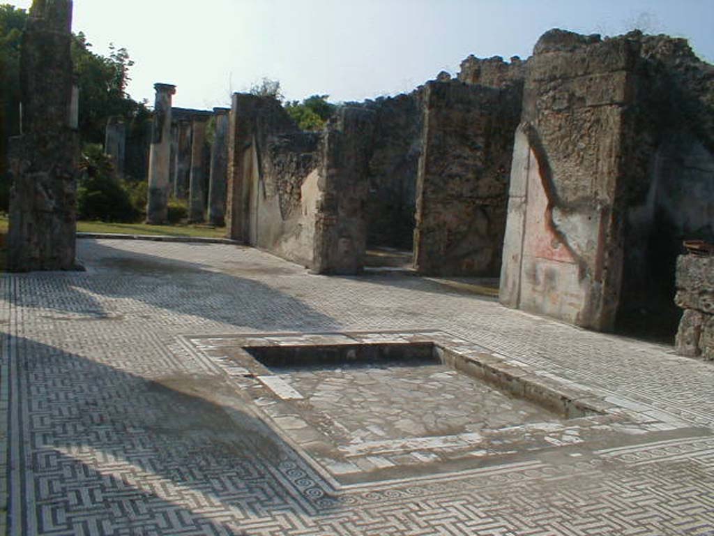 VIII.3.8 Pompeii. September 2004.
Looking south-west across atrium and decorated impluvium, towards tablinum, doorway to oecus and west ala, open onto atrium.