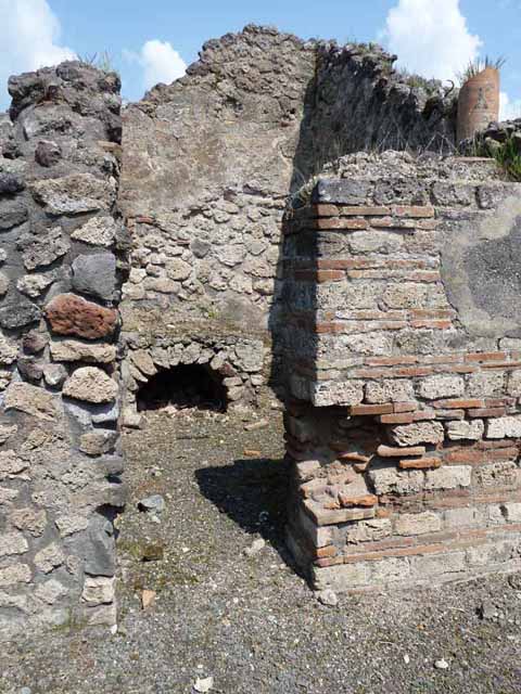 VIII.3.21 Pompeii. Detail of niche and garden from postcard dated 1st August 1939. According to Boyce, in the north wall of the garden was an arched niche adorned with an aedicula façade. The façade had a modelled stucco cornice running around the curve of the arch. It also had a heavy ledge projecting from the wall. The inside walls of the niche were covered with white stucco and outlined with red stripes. See Boyce G. K., 1937. Corpus of the Lararia of Pompeii. Rome: MAAR 14. (p.76, no.356, & Pl.3,5 photo by Warscher).
Photo courtesy of Drew Baker.