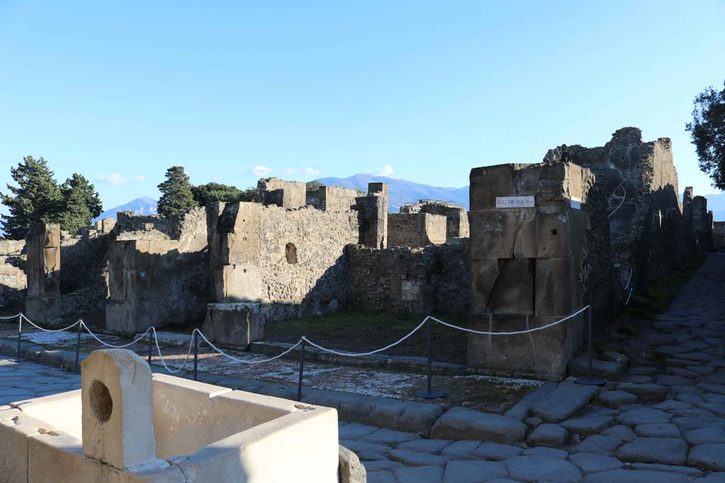 VIII.5.1 Pompeii. December 2018.
Looking south from behind fountain at VII.9.67 towards entrance doorway on east side of junction with Vicolo dei dodici Dei, on right.
Photo courtesy of Aude Durand.