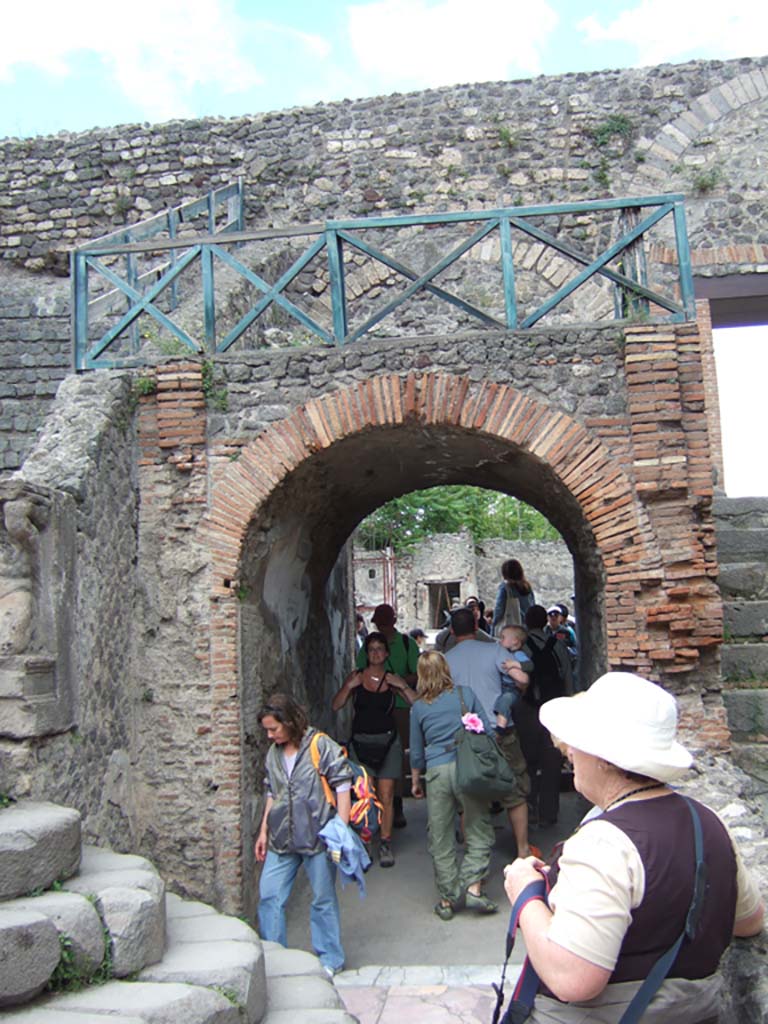 VIII.7.19 Pompeii. May 2006. East side with arched entrance.
Above the entrances on either side were the rectangular areas which had the seats reserved for the honoured guests.
These were called the Tribunals.
These were reached by the small narrow steps at the side and separated from the rest of the audience by a sloping wall to the north.
The Kneeling Atlas and Lion’s foot were at the lower end of this sloping wall on both the West and East sides.