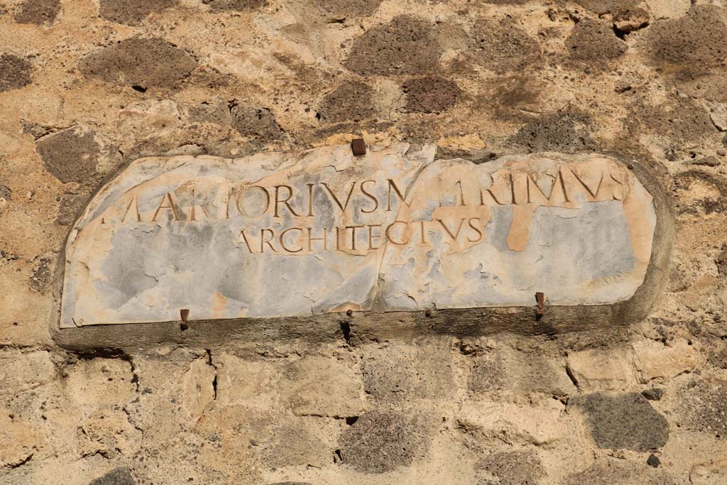 VIII.7.21 Pompeii. December 2018. Reproduction plaque on wall between theatres. Photo courtesy of Aude Durand.
The text on the original white marble slab (inv. 3834) provides the name of the architect involved in the refurbishment of the theatre –
M. Artorius Primus, freedman of Marcus.
The original plaque is now on display in the Campania Romana gallery of the Naples Archaeological Museum.
Also see VIII.7.20 Pompeii.