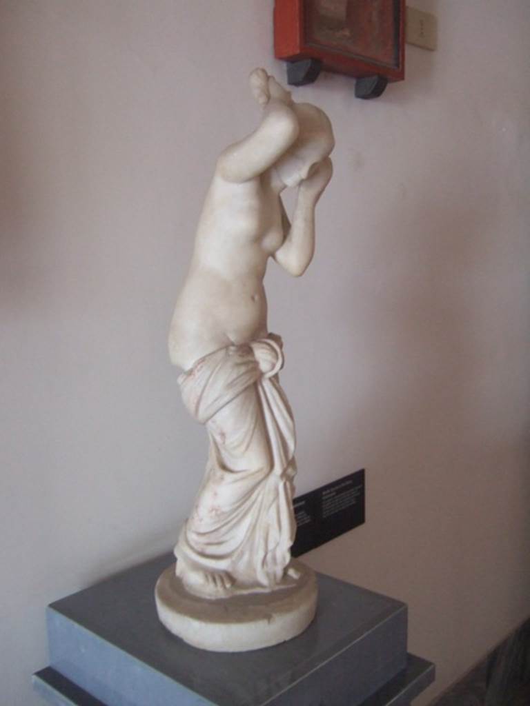 VIII.7.28 Pompeii. Marble statue of Venus Anadyomene (Venus drying her hair after a bath).
Found against the west wall of the colonnade in the south west corner.
Now in Naples Archaeological Museum. Inventory number 6298.