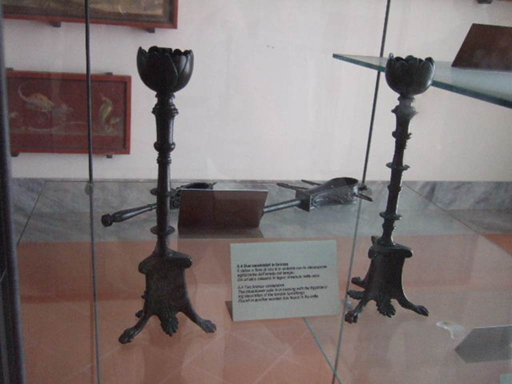 VIII.7.28 Pompeii. Found in another wooden box in the temple cella. Two similar but not identical bronze candelabra.
The tops are lotus flowers and the feet have lion’s paws with palm leaves between. The decoration of the stems differs on each.
Now in Naples Archaeological Museum. Inventory numbers 72192 and 72193.