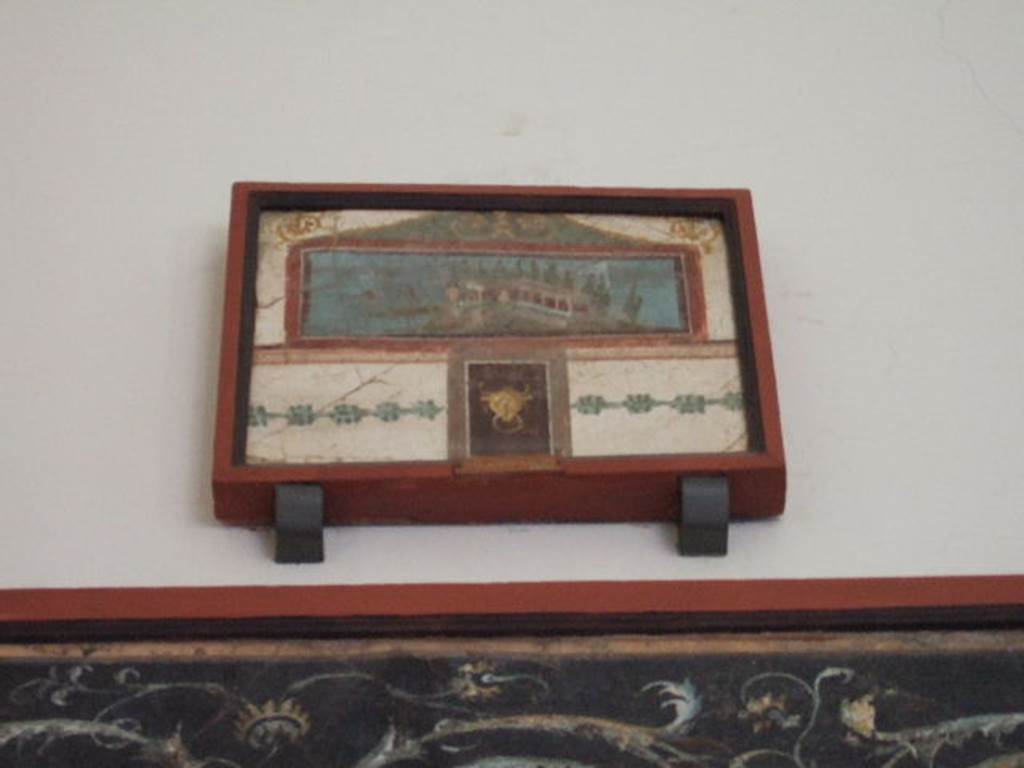 VIII.7.28 Pompeii. South part of east wall of portico. Picture with landscape, surmounted by a pediment and with a small panel underneath with a bovine head.
Now in Naples Archaeological Museum. Inventory number 9444.