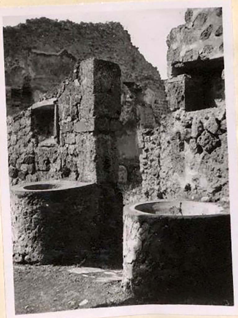 IX.1.3/33 Pompeii. Pre-1943.
Looking south-west from oven towards two small tubs, above both were niches. Photo by Tatiana Warscher.
See Warscher, T. Codex Topographicus Pompeianus, IX.1. (1943), Swedish Institute, Rome. (no.9), p. 22.
According to Boyce –
“Against the wall facing the oven stand two small masonry basins and in the wall above each is a rectangular niche called by Fiorelli “la nicchia dei Penati”; there remains today no indication of religious purpose.”
See Boyce G. K., 1937. Corpus of the Lararia of Pompeii. Rome: MAAR 14, (379).