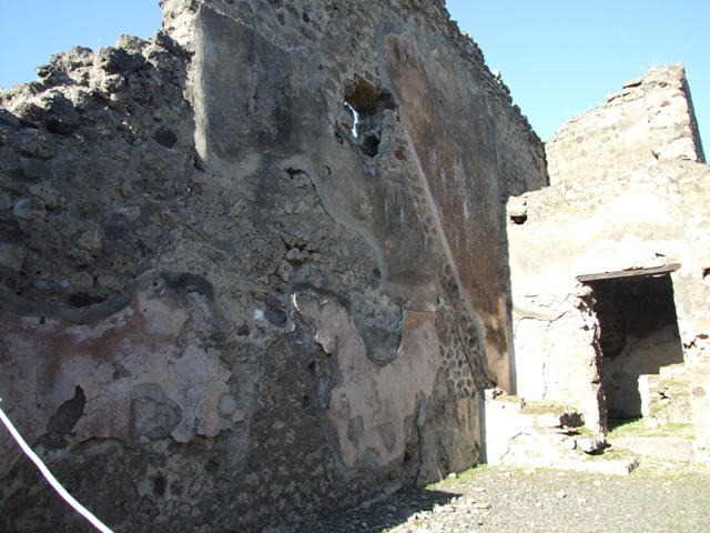 IX.1.4 Pompeii. March 2009. Doorway to rear kitchen room in east wall of shop. In December 1852, an inscription was found in this room:
Carmina(m)
communem ne
arma virumque cano tro   [CIL IV 2361]
Now in Naples Archaeological Museum.  Inventory number 111970.
See Pagano, M. and Prisciandaro, R., 2006. Studio sulle provenienze degli oggetti rinvenuti negli scavi borbonici del regno di Napoli.  Naples : Nicola Longobardi.  (p.167)
According to Fiorelli it read:
CARMINA
      COMMVNEMNE
ARMA . VIRVMQVE CANO TRO
See Pappalardo, U., 2001. La Descrizione di Pompei per Giuseppe Fiorelli (1875). Napoli: Massa Editore. (p.137)
