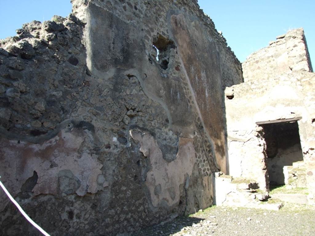 IX.1.4 Pompeii. March 2009. Hearth against south wall in rear room.
According to Boyce, somewhere in this shop on an east wall was a panel of special stucco. In this panel were painted two red serpents confronted at an altar. A tile was embedded in the wall below their heads, to serve as a shelf for offerings. There does not appear to be any signs today of either a tile or painting.
See Boyce G. K., 1937. Corpus of the Lararia of Pompeii. Rome: MAAR 14. (p.79)
According to Eschebach, the serpents were painted on the right pilaster of the shop room.
See Eschebach, L., 1993. Gebäudeverzeichnis und Stadtplan der antiken Stadt Pompeji. Köln: Böhlau. (p.398)

