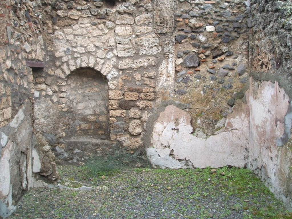 IX.1.11 Pompeii. December 2004. Rear, east wall of shop with arched niche. According to PPP, the walls were plastered with cocciopesto and a violet/dark red vertical stripe can be seen on the south wall, on the right. See Bragantini, de Vos, Badoni, 1986. Pitture e Pavimenti di Pompei, Parte 3. Rome: ICCD. (p.386).
For the list of bronze, iron,terracotta, glass, bone and amphorae found in this shop, and linked to IX.1.11, See Gallo, A (2001). Pompei, L�Insula I della Regione IX, Settore Occidentale (p.61), in SAP book no. 1 (L�Erma di Bretschneider).
